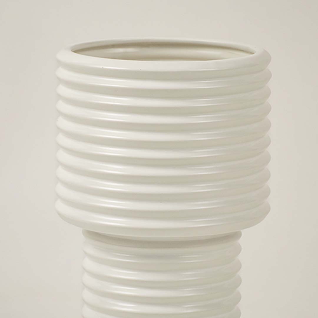 Closeup of white ribbed ceramic vase showing glossy finish and smooth lines ideal for contemporary home decoration.