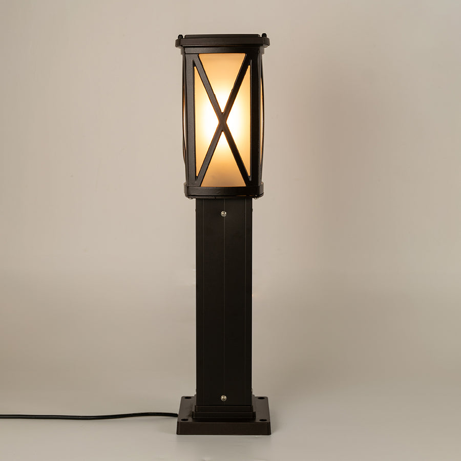 Modern black outdoor bollard light with warm glowing panels for elegant exterior decor styling use.