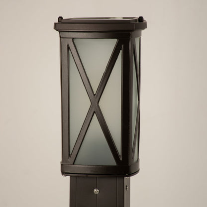 Closeup of black outdoor bollard light with cross metal detailing for modern exterior decor styling.