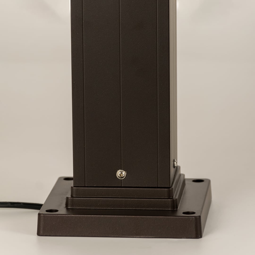Closeup of black outdoor bollard light base with modern metal finish for elegant exterior decor use.