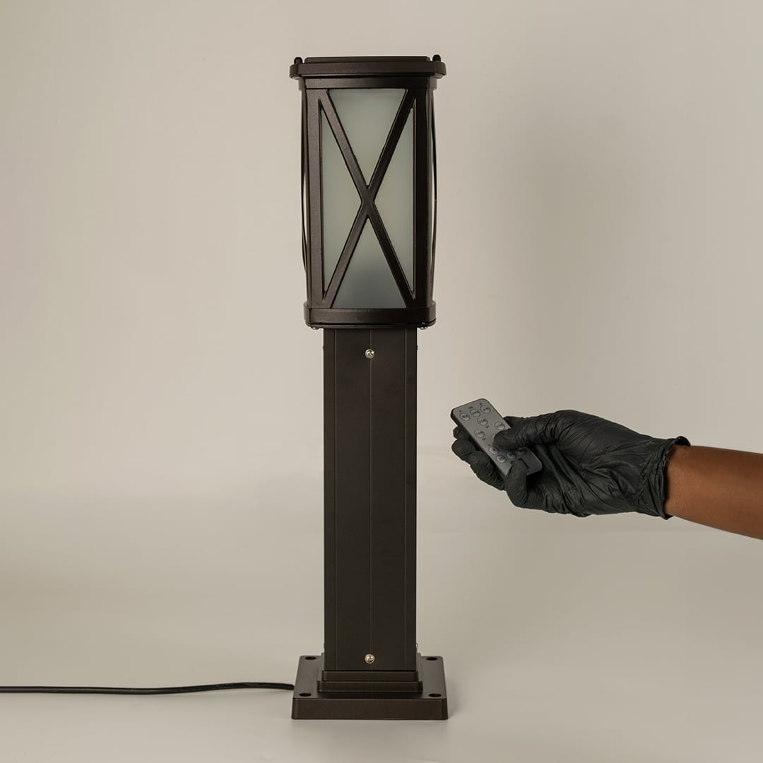 Black outdoor bollard light with remote control for smart exterior lighting and decor styling use.