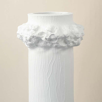Detailed closeup of white ceramic vase showing textured finish and floral crown detail for decorative styling.