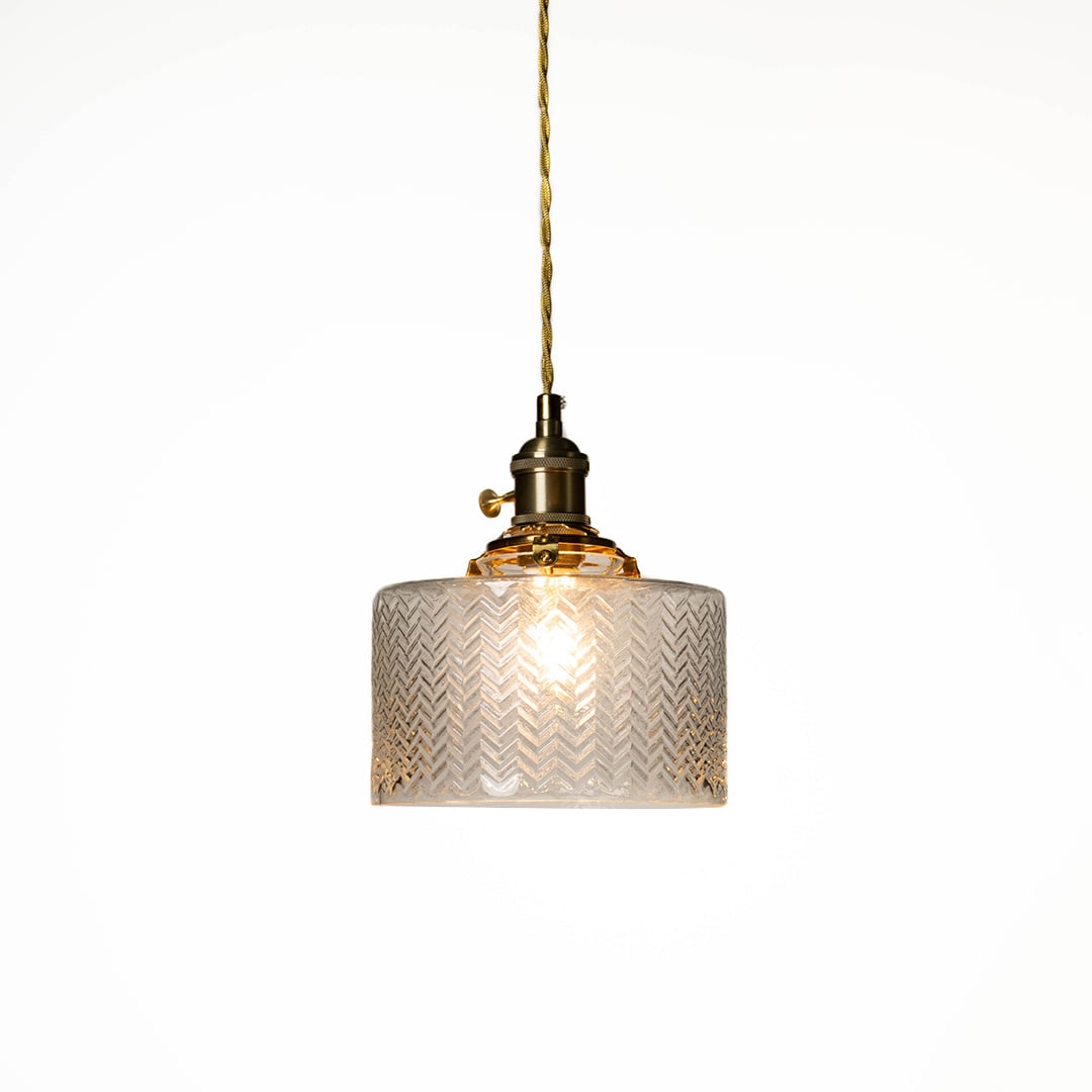 Textured clear glass and brass metal pendant light designed for elegant dining room decor spaces.