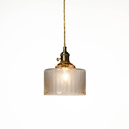 Textured clear glass and brass metal pendant light designed for elegant dining room decor spaces.