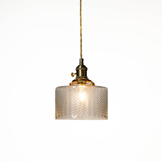 Textured clear glass and brass metal pendant light designed for elegant dining room decor spaces.
