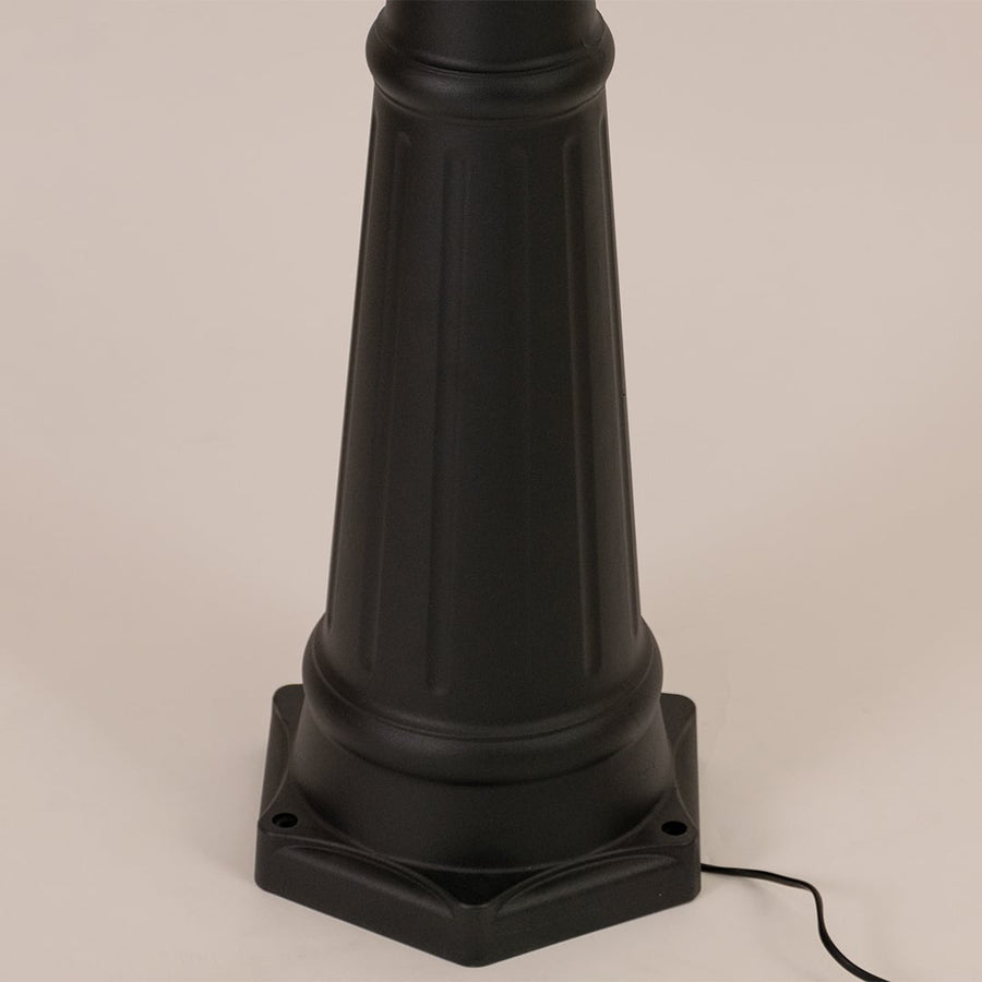 Detailed close up of black metal post lamp base showing textured pole construction decorative rings and foundation mounting design.