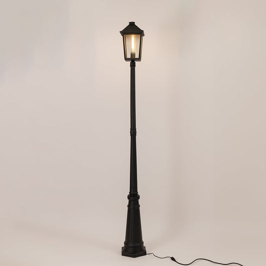 Illuminated black outdoor post lamp with glowing lantern head and textured glass panels on clean white background display.