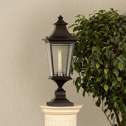 Black metal lantern with ribbed glass Light On placed next to a ficus plant Lifestyle image for patio decor.