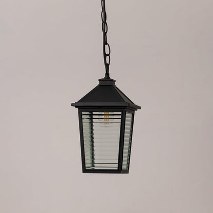 Classic black metal outdoor hanging light with textured glass and chain suspension switched off on minimal white backdrop.