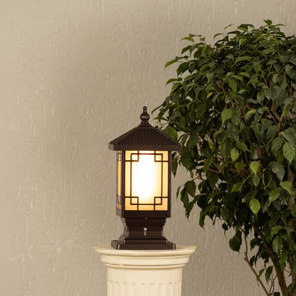Black metal outdoor post lantern Light On mounted on a stone pillar Traditional garden gate lighting Main Lifestyle image at night.
