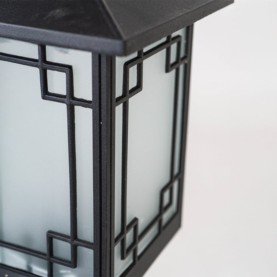 Closeup of black outdoor garden light with geometric metal detailing for luxury exterior decor use.