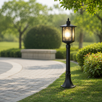 Craftsman black iron cage glass landscape post lantern light on green grass lawn for backyard garden pathway styling patio.
