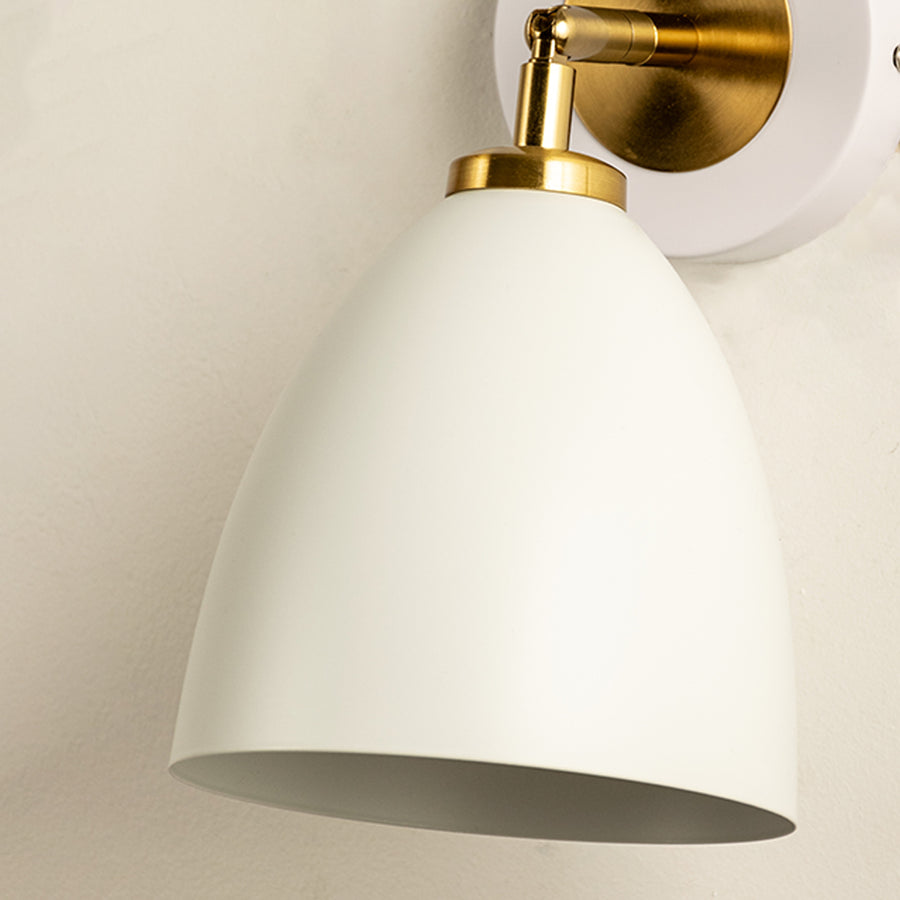 Closeup of white metal wall light with gold finish for stylish bedroom hallway and living room decor styling.