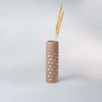 Beige geometric ceramic vase displayed in a subtle lifestyle scene highlighting its tall shape and contemporary textured surface.