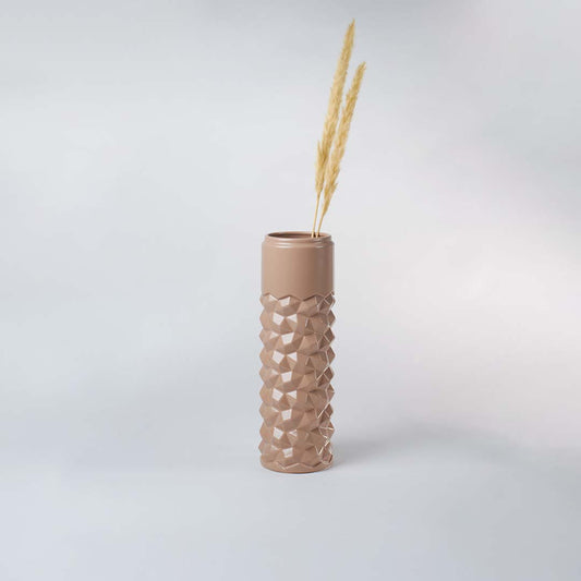 Beige geometric ceramic vase displayed in a subtle lifestyle scene highlighting its tall shape and contemporary textured surface.