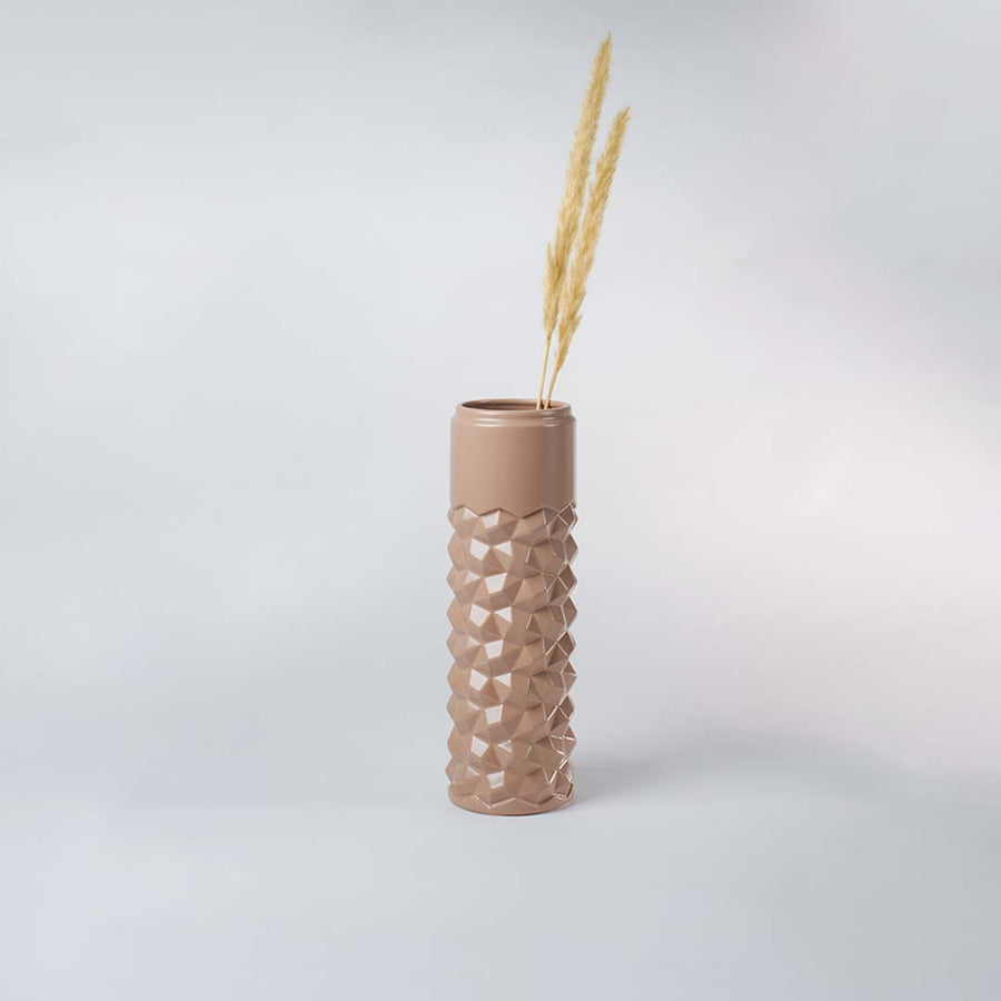 Beige geometric ceramic vase displayed in a subtle lifestyle scene highlighting its tall shape and contemporary textured surface.