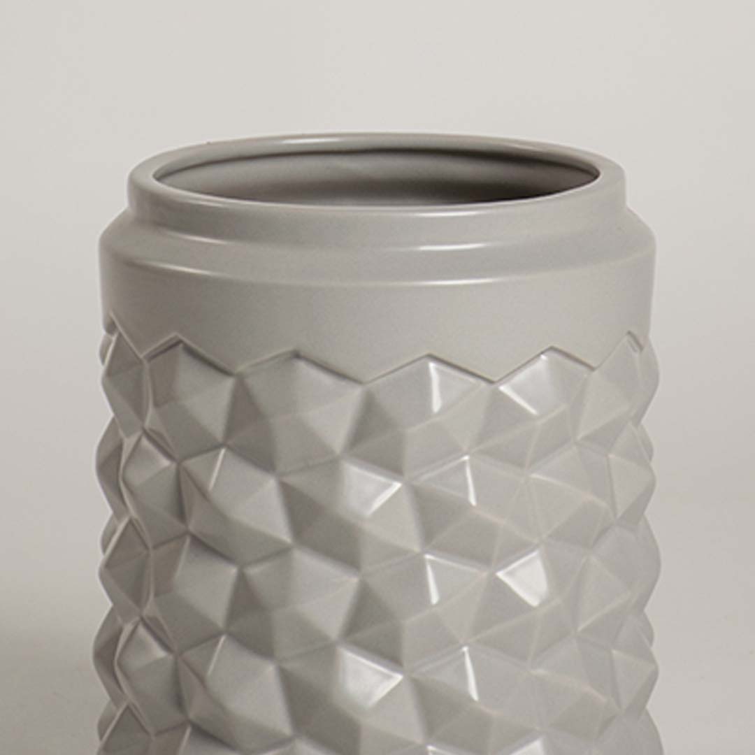 Detailed close view of the grey ceramic vase showing its raised geometric texture and smooth finish for a modern decorative appeal.
