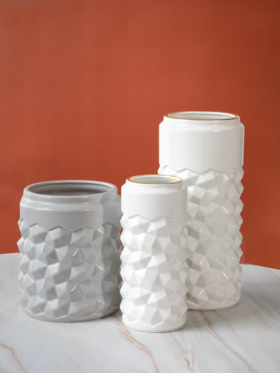 White textured ceramic vase arranged with complementary decor pieces creating a grouped display that adds a modern look to interiors.