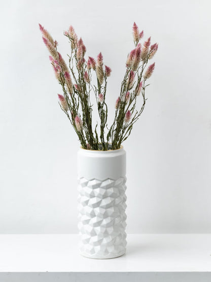 Modern white ceramic vase with raised geometric texture placed in a bright lifestyle setup enhancing the decor with a stylish touch.