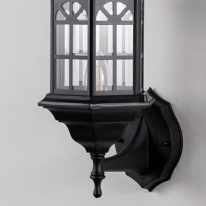 Detailed closeup of traditional outdoor wall lantern showing black metal housing glass panels and curved arm craftsmanship.
