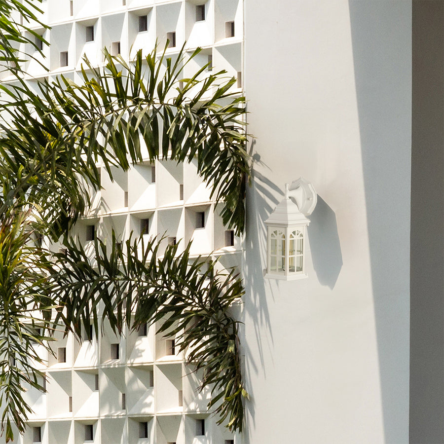 White outdoor lantern with the light off displayed on a clean exterior wall highlighting its classic window style glass panels and bright modern outdoor design.