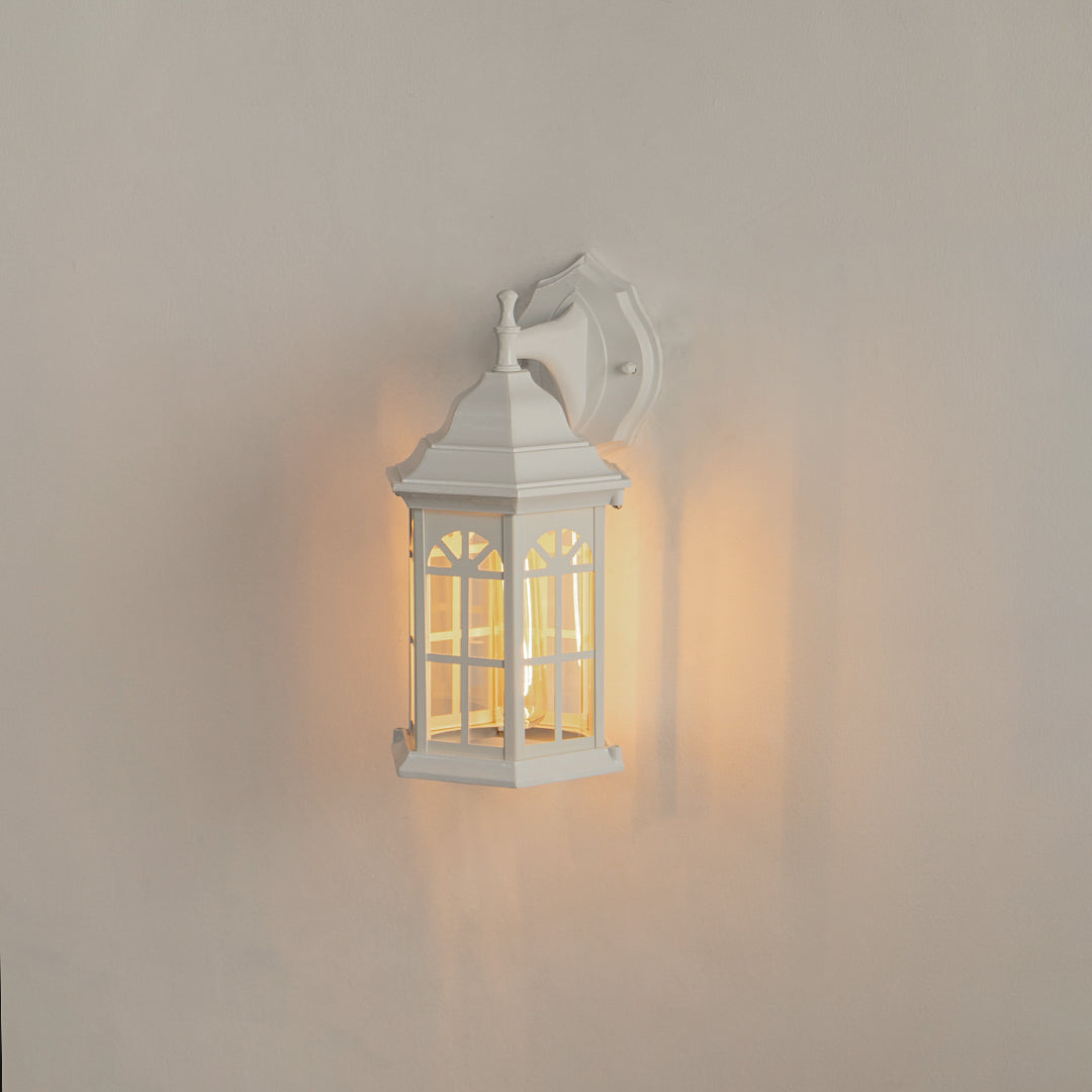 White aluminum outdoor wall lantern on white background with an arched paneled glass shade for vintage porch decor.