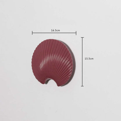 A maroon shell shaped decorative wall plate displayed with measurements showing 16.5 cm width and 15.5 cm height offering clear size details for easy styling.