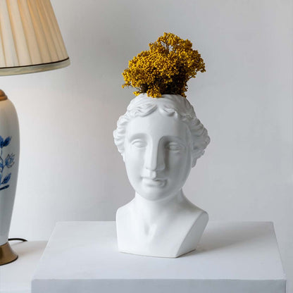 Artistic white bust sculpture placed on a minimal stepped setup adding a modern gallery inspired decorative touch to contemporary interiors.