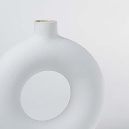Closeup of large white ceramic donut vase showing smooth glossy surface premium ceramic material and modern decorative form for interior styling.
