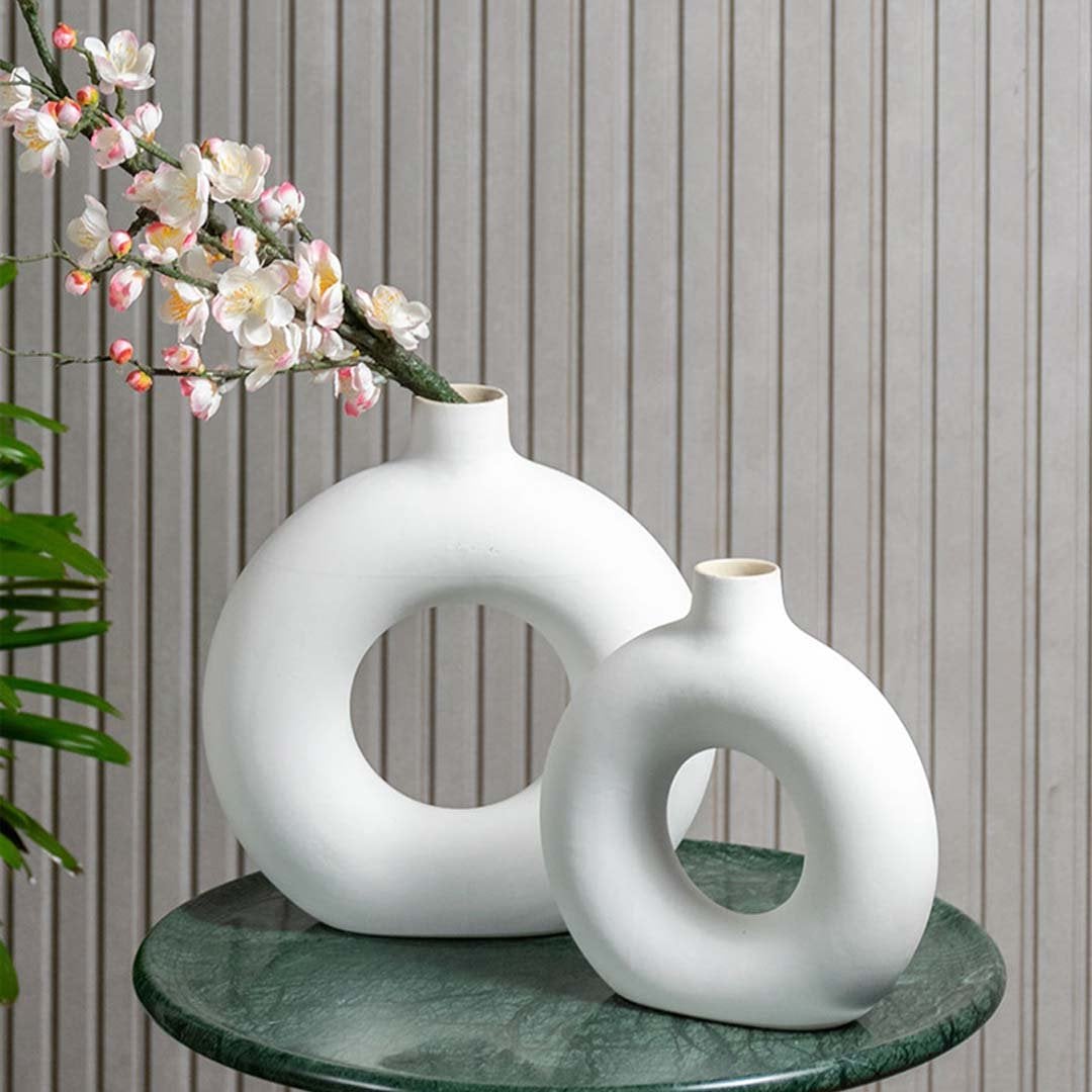 Stylish round ceramic vase with flowers on a marble table – modern minimalist home decor accessory.