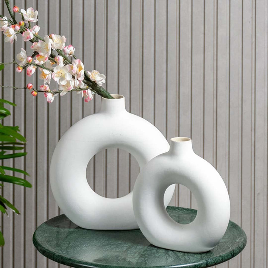 Stylish round ceramic vase with flowers on a marble table – modern minimalist home decor accessory.