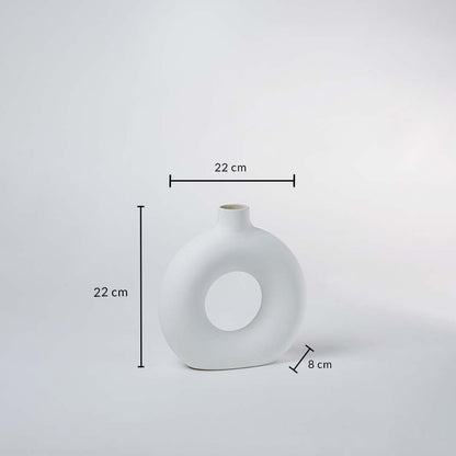 Closeup of white ceramic vase with round hollow center – elegant minimalist vase for home decoration.