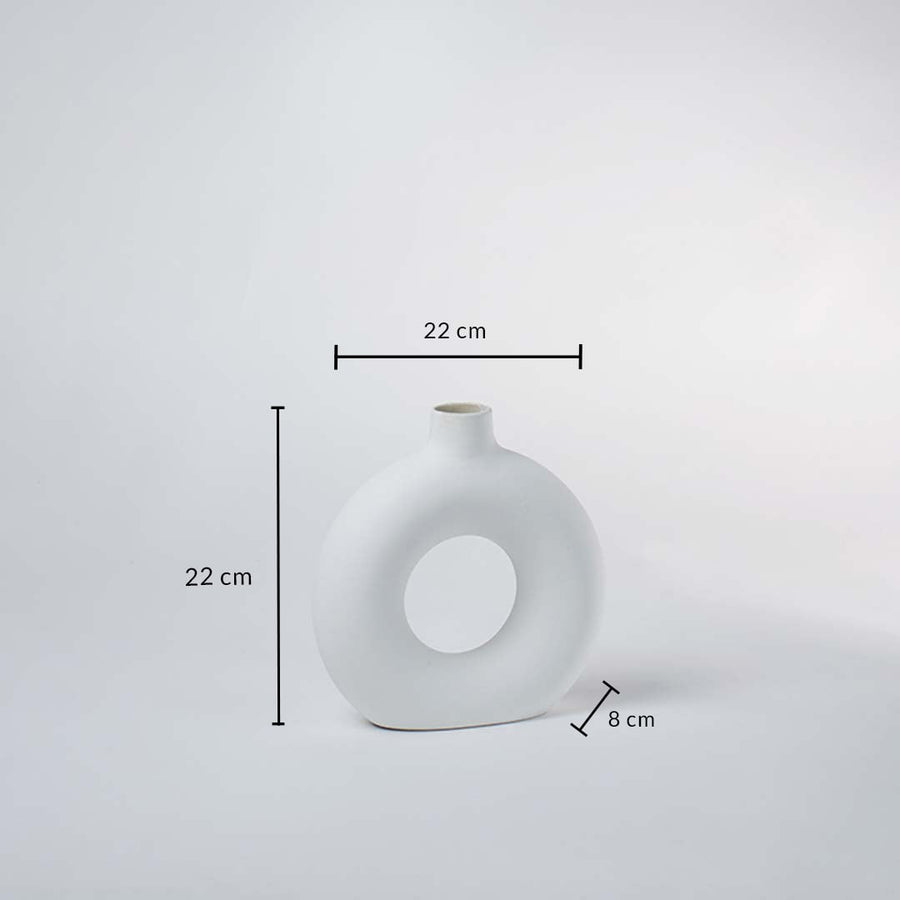Closeup of white ceramic vase with round hollow center – elegant minimalist vase for home decoration.