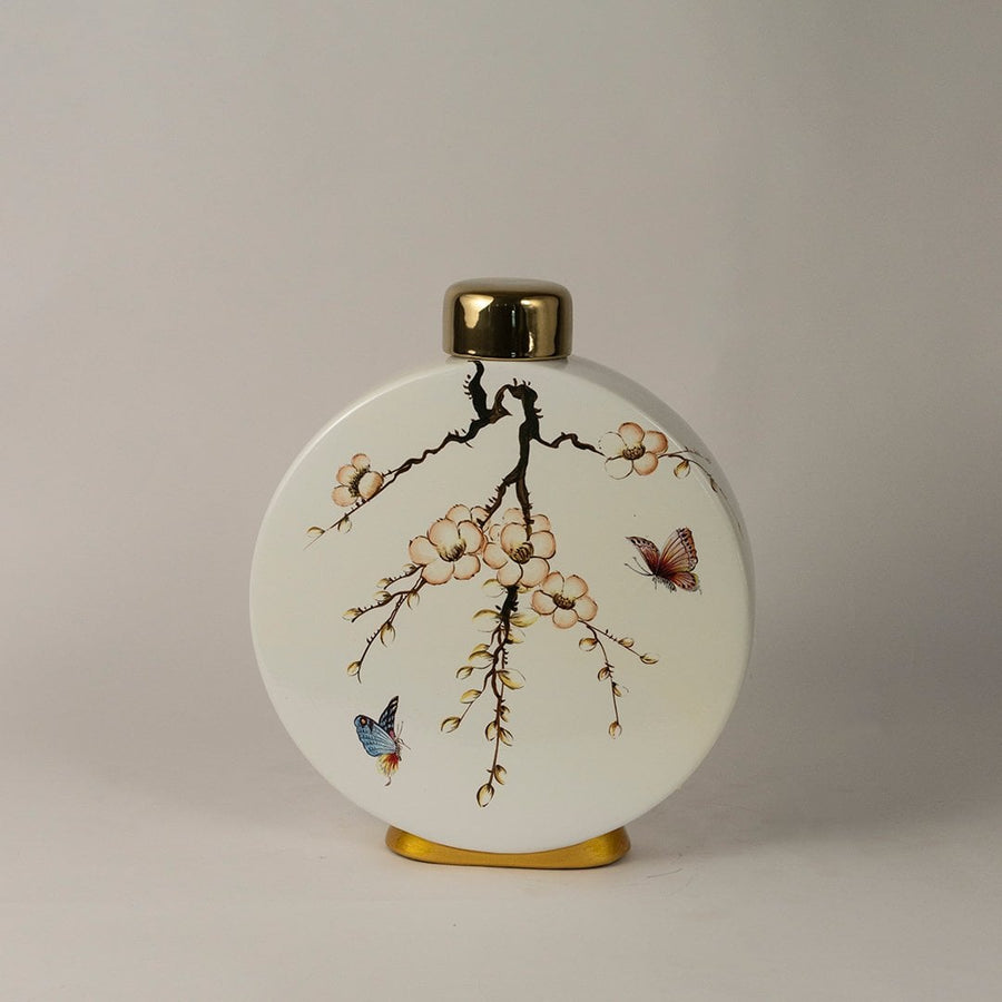 Round ceramic jar against white background emphasizing glossy finish and gold-topped lid.