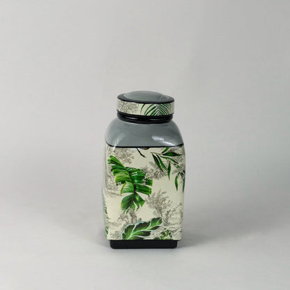 Tropical leaf jar placed against white background highlighting hand painted tropical leaves.