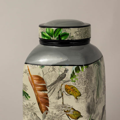 Closeup of tropical bird jar showing fine leaf detailing and hand painted bird design.