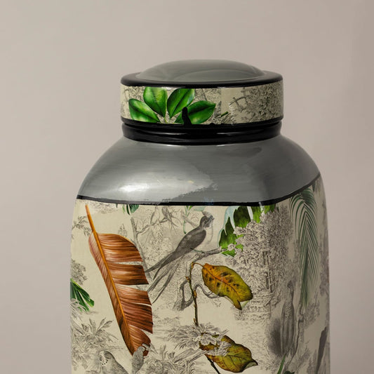 Closeup of tropical bird jar showing fine leaf detailing and hand painted bird design.