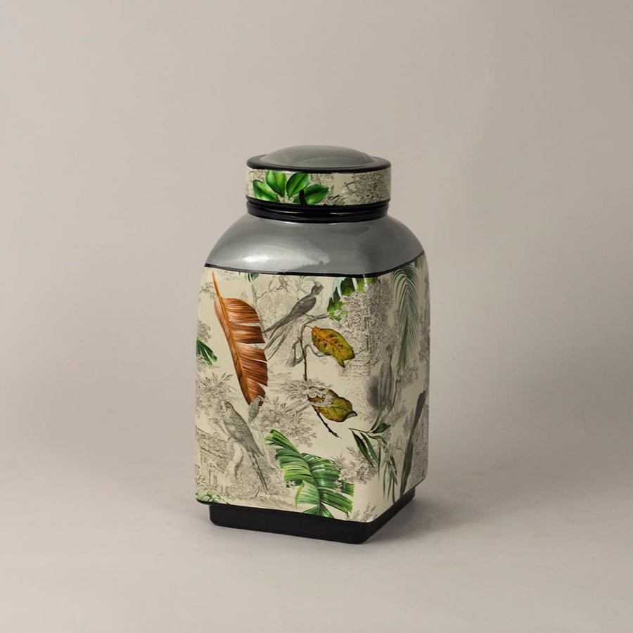 Side angle of tropical bird jar showing smooth shape glossy finish and tropical foliage design.