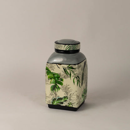 Tropical leaf jar captured from a side angle showing curved design and artistic greenery print.