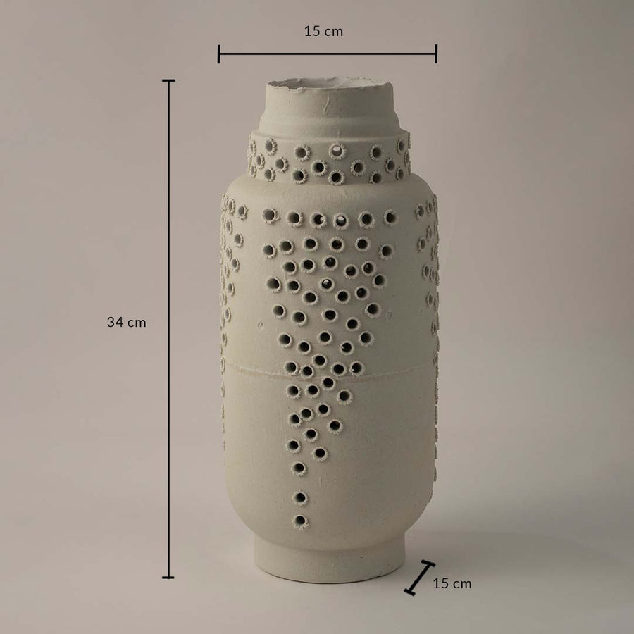White ceramic perforated vase with artistic detailing shown with 34 cm height and 15 cm diameter for contemporary interiors.