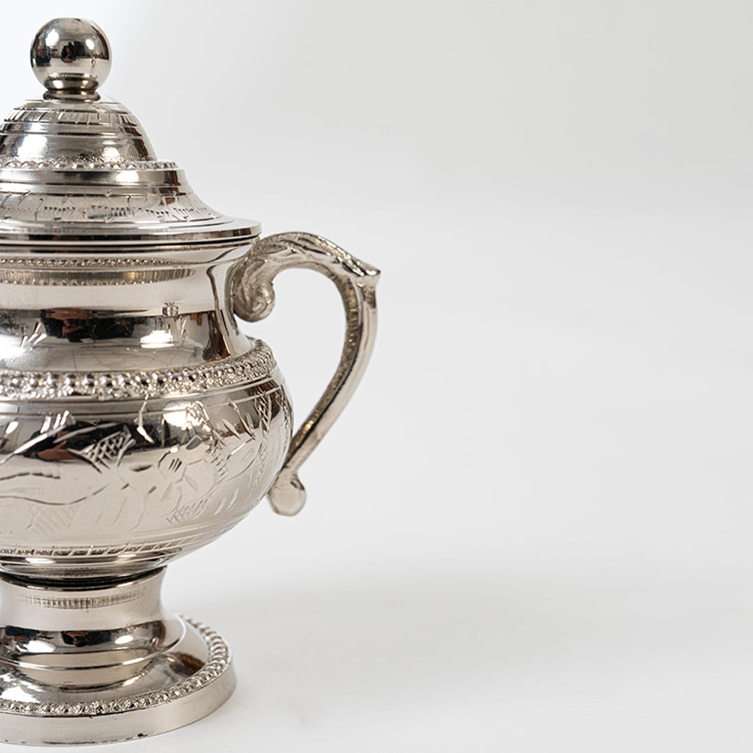 Silver sugar bowl and creamer set with decorative handles and pedestal bases displayed on a white background.