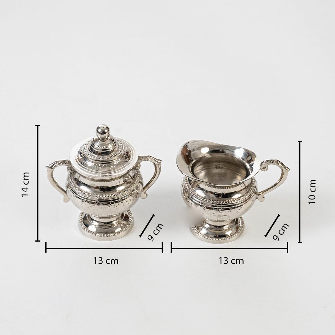 Silver sugar bowl and creamer set with decorative handles on white background with measurements 14 cm by 12 cm.