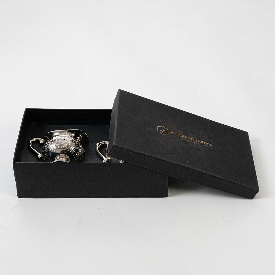 Ornate silver sugar and creamer set placed in a black gift box with lid open for premium packaging presentation.