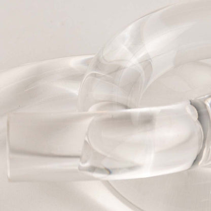 Artistic clear glass knot detail shot highlighting smooth curves and reflective crystal quality.