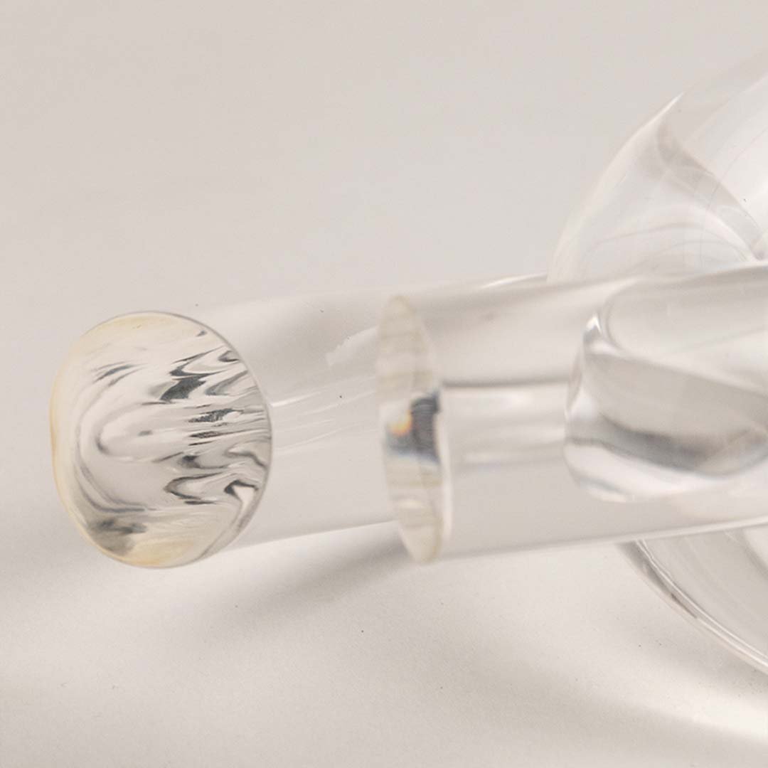 Closeup of clear glass decorative sculpture with rounded form highlighting refined craftsmanship and artistic detailing.