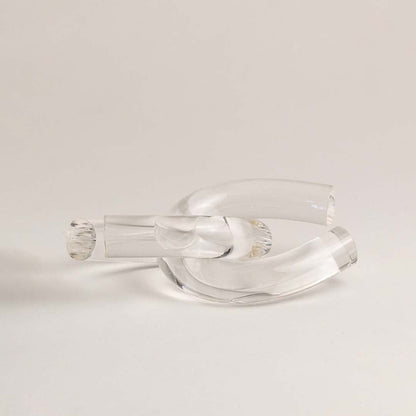 Clear glass knot decorative accent shown on white background highlighting its elegant sculptural design for home styling.