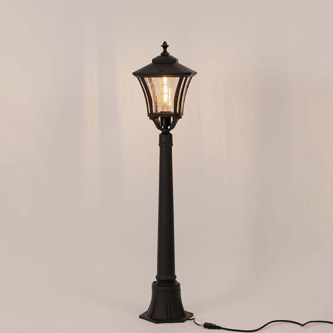 Vintage black outdoor garden light with warm glowing bulb for elegant exterior decor styling use.