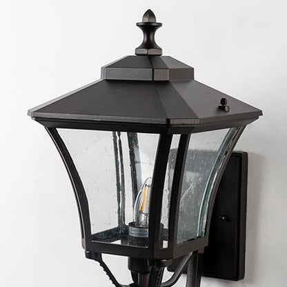 Closeup of outdoor wall lantern with black metal frame and clear glass panels showing classic design and durable exterior build quality.