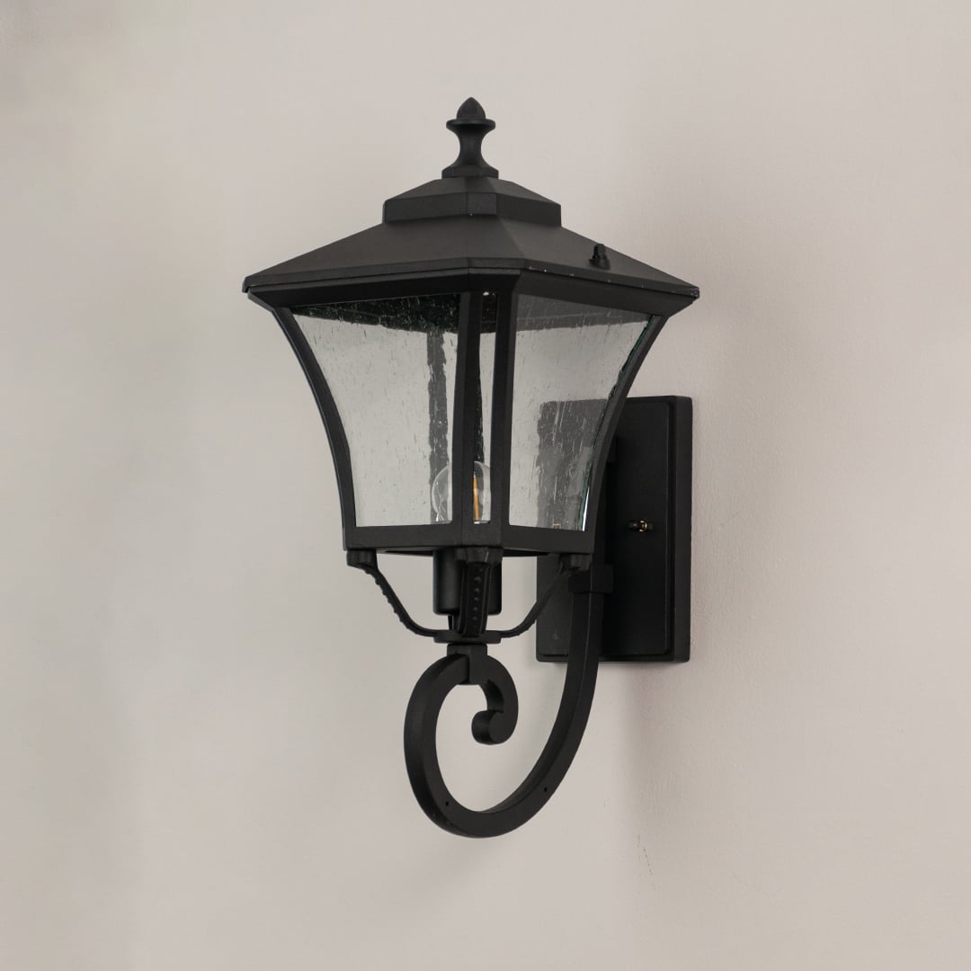 Black metal outdoor lantern with textured glass shown unlit highlighting durable build for entryway and porch walls.