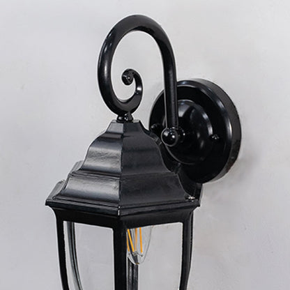 Detailed closeup of lantern wall light showing black metal frame and clear glass design for outdoor lighting.